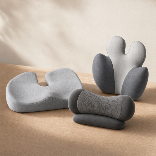 The VESU cushion set and Neck Reset Pillow arranged together on warm oak